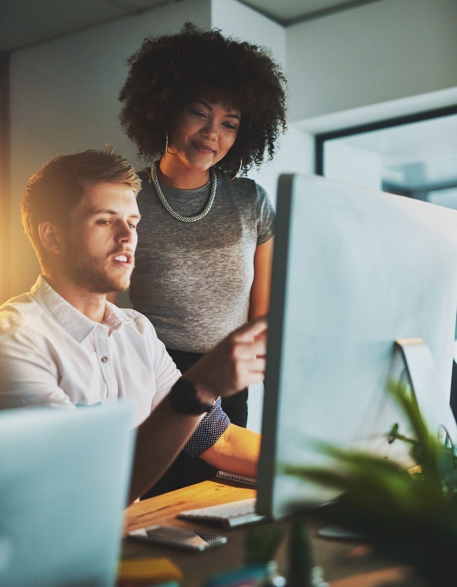Young man and woman chat over a laptop in an office setting_flipped