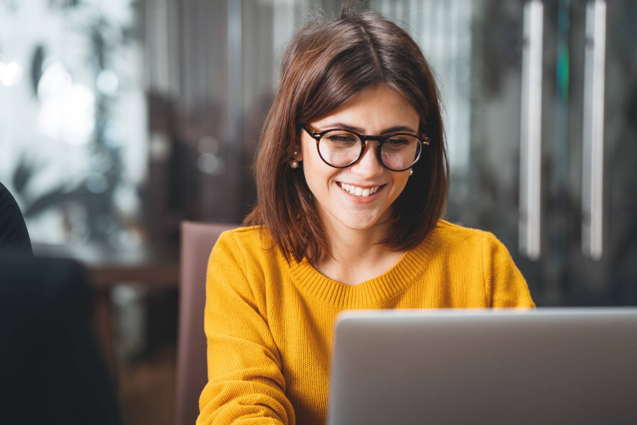 Young woman using laptop in office setting-min